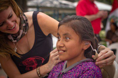 Hilton fits a child in Peru for a hearing aid as part of a Starkey Global Mission. (Courtesy of LSTN)